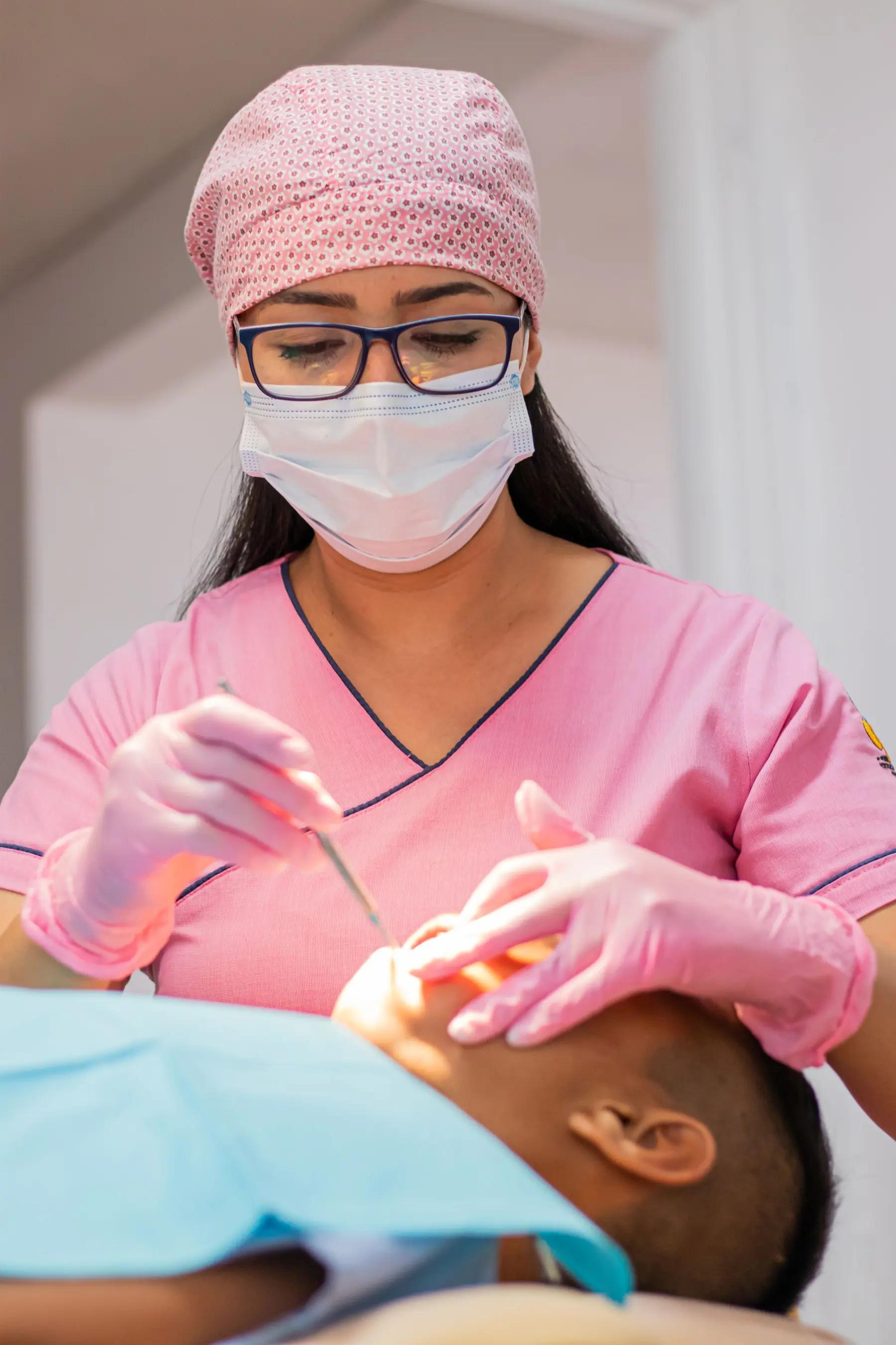 Close view of gloved hands holding instruments during a skin treatment.