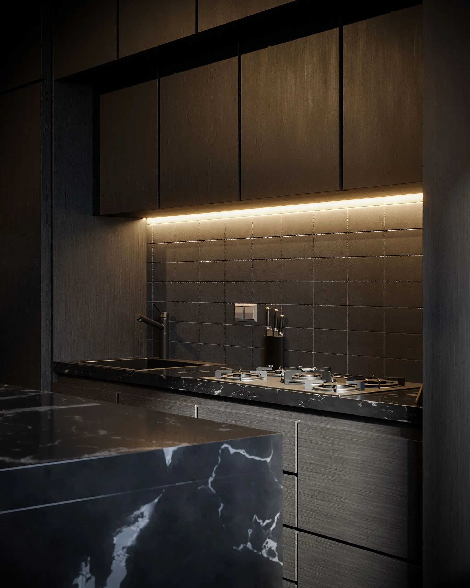 A dark kitchen with brass-lit cabinets, a black marble island and a built-in hob.