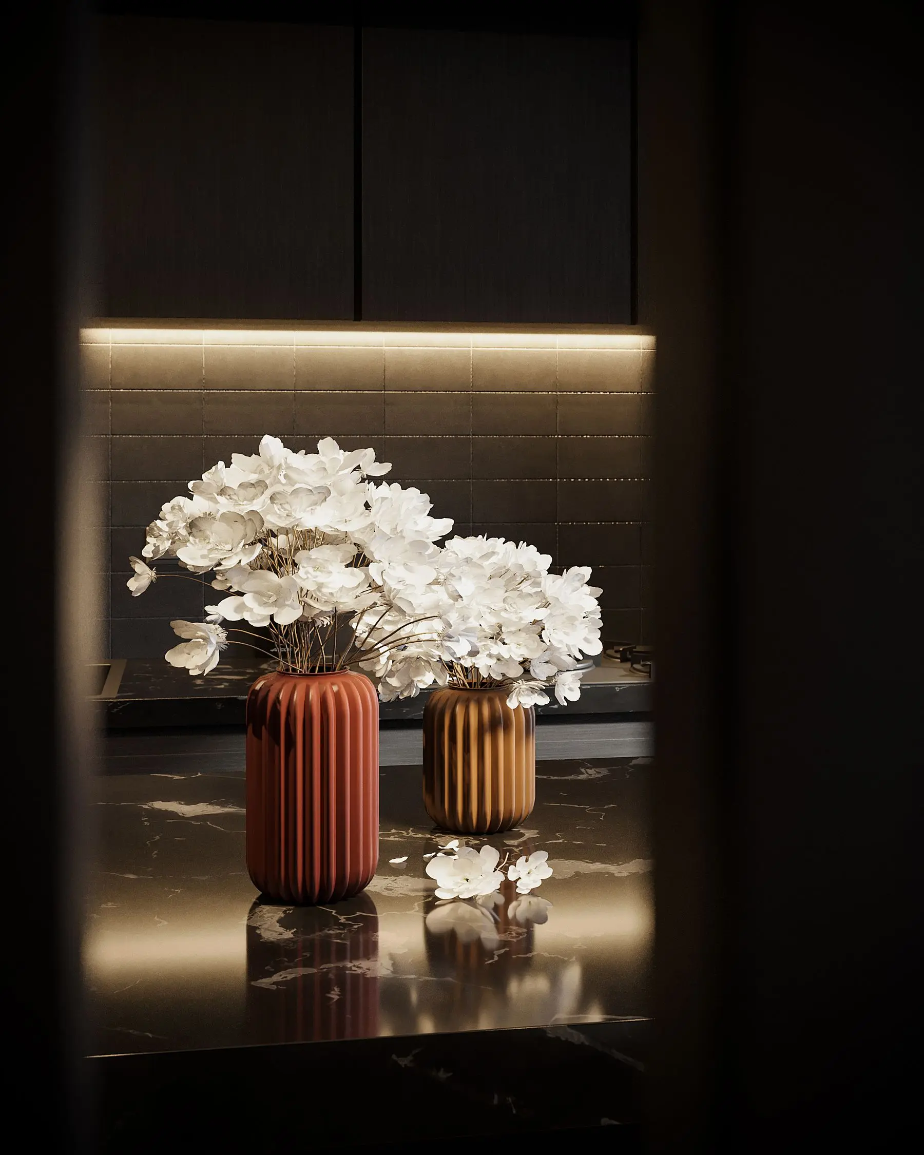 White flowers in ribbed copper vases on a dark marble counter.