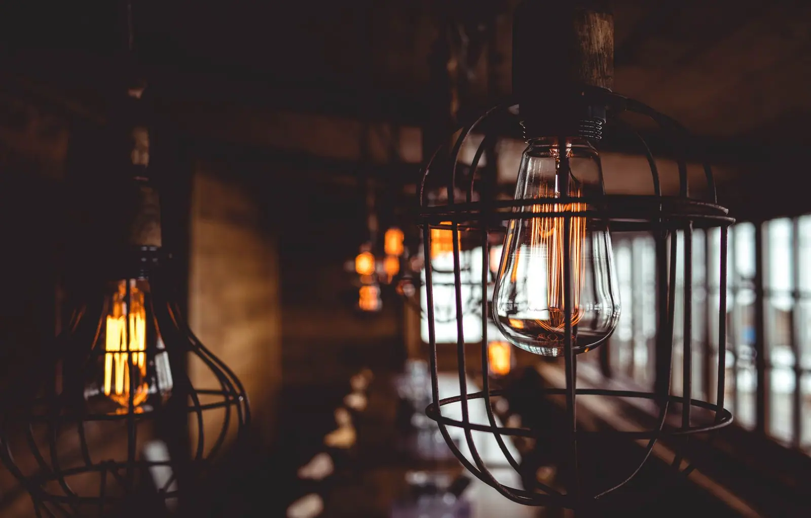 Caged filament lamps glowing amber in a dark room